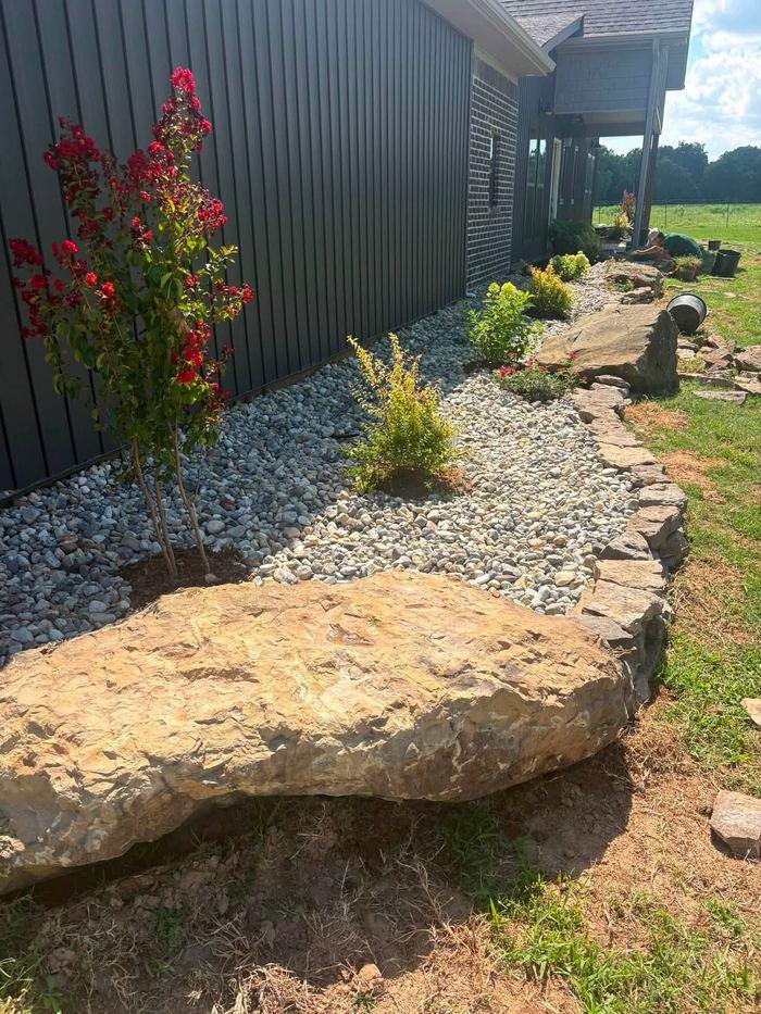 A crepe myrtle set into a boulder and river-rock landscape bed