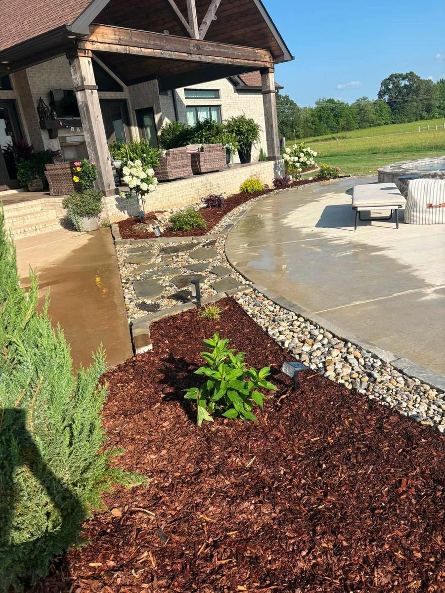 A completed patio and garden bed installation with flagstone path and hydrangeas