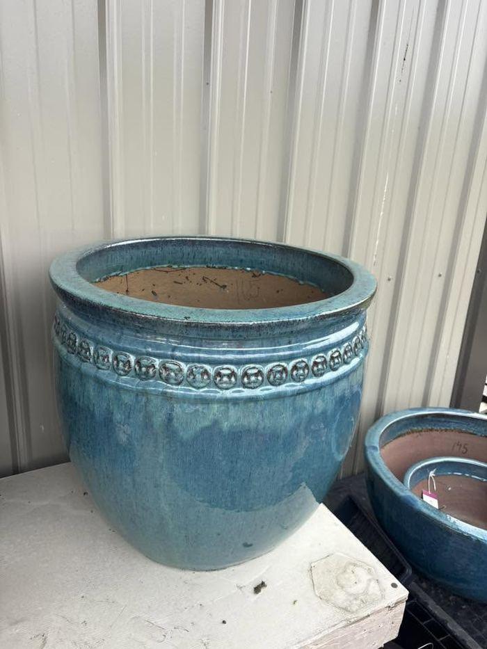 A large glazed teal ceramic planter