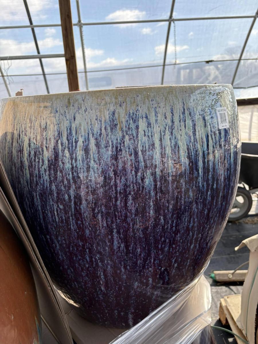 Close-up of a drip-glazed ceramic planter in blue and cream